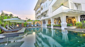 A modern hotel with a pool area, sun loungers, and a covered seating area. - Central Residence Suite  (Krong Siem Reap)