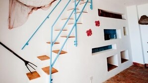 A staircase with blue railings, a hanging net, and a pendant light.