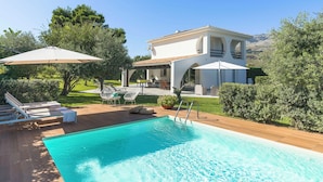 A modern villa with a swimming pool, outdoor seating, and a covered patio. - Panoramic villa with pool in front of the beach (Scopello)