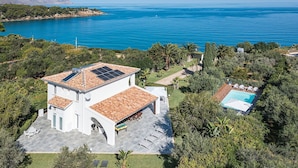 A white villa with a tiled roof, a swimming pool, and a view of the sea. - Panoramic villa with pool in front of the beach (Scopello)