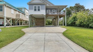 A two-story house with a covered porch and a front yard. - Bonne Mer: Three bedroom, two bathroom house in Oak Island close to shopping and (Oak Island)