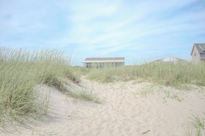 A sandy beach with a modern building in the background.