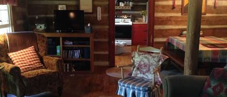 Interior acogedor de una cabaña de madera con sala de estar, comedor y cocina.