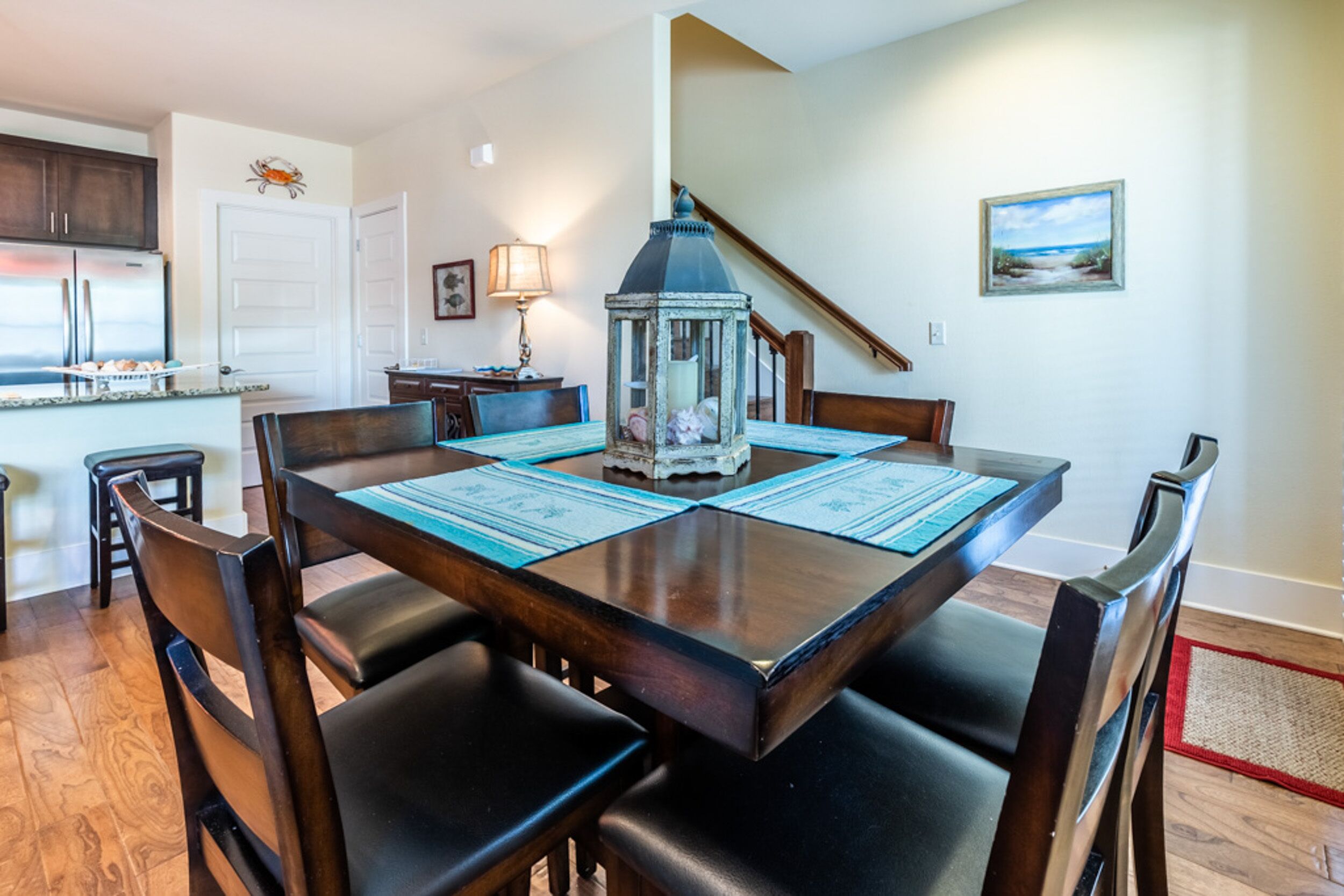 A dining area with a wooden table, black chairs, and a decorative lantern.