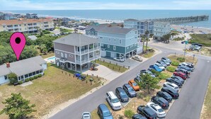 Un quartier résidentiel situé sur la côte, avec des immeubles à plusieurs étages, un parking et une jetée qui s’avance dans l’océan.