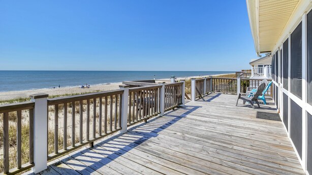 A wooden deck with a railing overlooking a beach. - Blu Malibu: 5 Bed/3 Bath Oceanfront Home, Walking Distance to Davis Canal. (Oak Island)