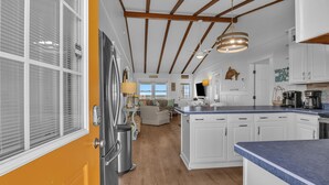 A spacious kitchen with white cabinets, a blue countertop, and a wooden ceiling. - Blu Malibu: 5 Bed/3 Bath Oceanfront Home, Walking Distance to Davis Canal. (Oak Island)