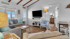 A living room with a sofa, armchairs, a coffee table, and a television. - Blu Malibu: 5 Bed/3 Bath Oceanfront Home, Walking Distance to Davis Canal. (Oak Island)