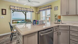 Una cocina con una isla central, lavavajillas y vistas al exterior.