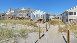 A beachfront property with multiple houses connected by wooden walkways.