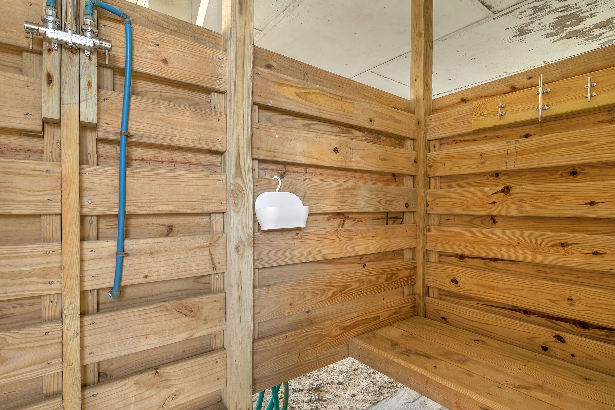 A wooden cabin interior with a metal water spigot and a white basin.
