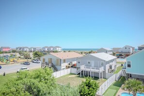 A residential area with houses, a swimming pool, and a view of the ocean. - Kiki Hut: Swimming Pool, Great Ocean Views, Dog-Friendly (Oak Island)