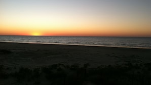 Uma praia ao pôr do sol com céu limpo.