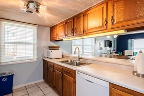 Enjoy cooking in this well-lit kitchen with a stainless steel sink and microwave.