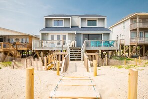 Enjoy stunning ocean views from the spacious deck, leading to a modern entrance with a staircase.
