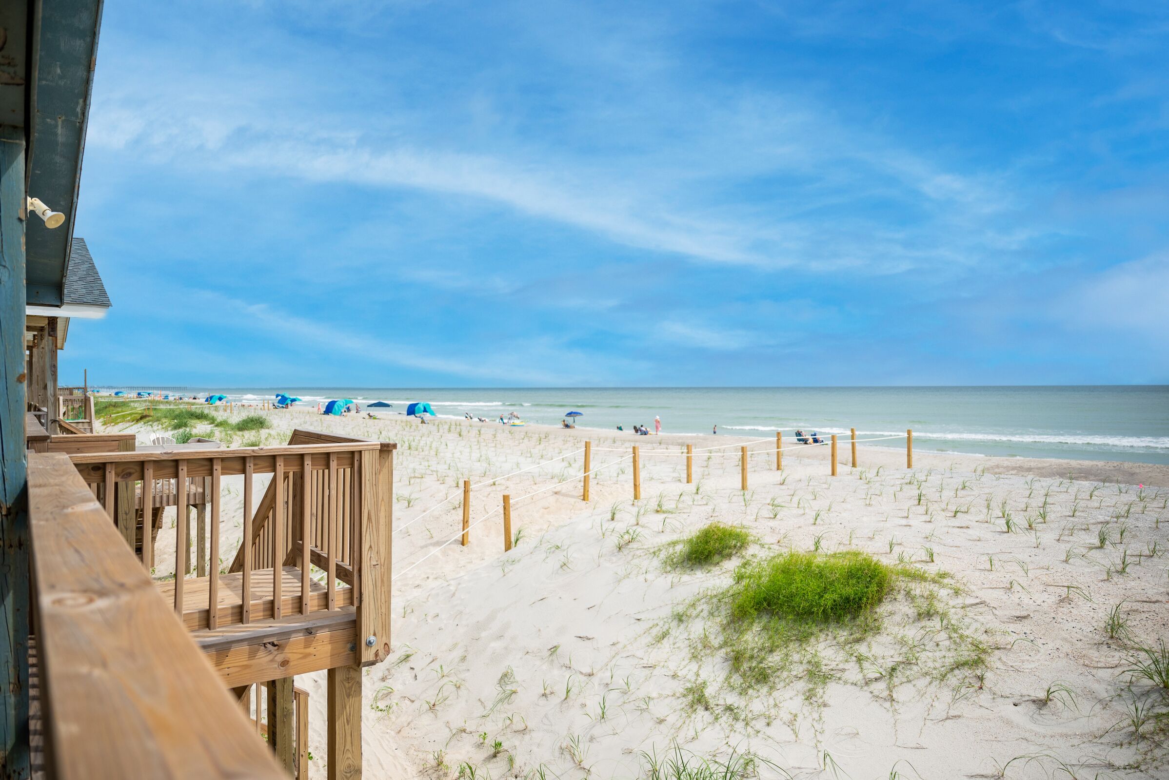 Ein Strand mit einer Holzterrasse und Blick auf den Ozean.