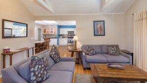 A modern living room with a sofa set, a coffee table, and a dining area. - Pleasure Point Oasis ~ Family and dog-friendly yard ~ Off-street parking (Santa Cruz)