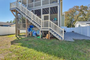 Stunning two-story home with a spacious staircase and upper deck featuring a railing and glass panels.