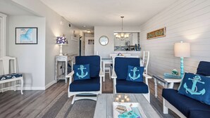 Ein wohnzimmer im nautischen Stil mit Essbereich, Küche und Meerblick.