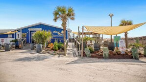 Un edificio con un letrero que dice "Island Way Restaurant & Bar" y un área de estar cubierta al aire libre.