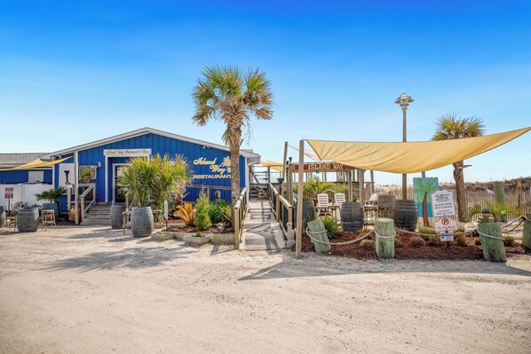 A building with a sign reading "Island Way Restaurant & Bar" and a covered outdoor seating area. - Beach Treat: Coastal Chic Home with Spacious Deck, Close to Beach Access (Oak Island)