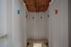 A small, enclosed space with a wooden ceiling and white walls, featuring a single wooden bench at the bottom. - Beach Treat: Coastal Chic Home with Spacious Deck, Close to Beach Access (Oak Island)