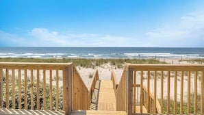 Un paseo marítimo de madera que conduce a una playa con vistas al océano.