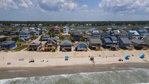 A coastal residential area with houses, a beach, and a view of the ocean. - Pelican Crossing: Oceanfront Home w/Spiral Staircase (Oak Island)