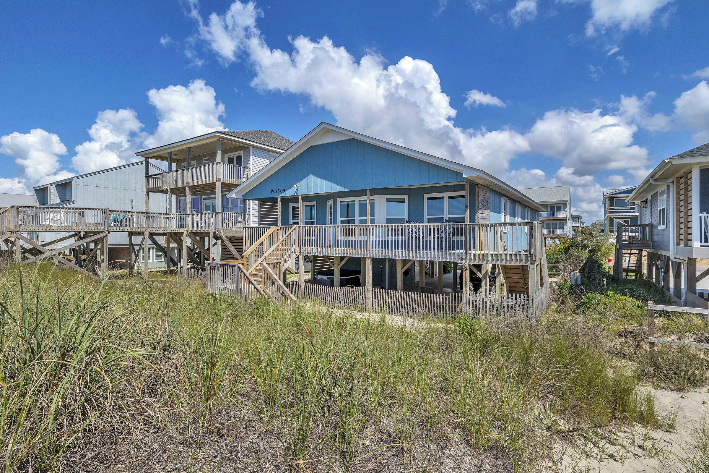 A beachfront property with multiple wooden decks and a covered outdoor area.