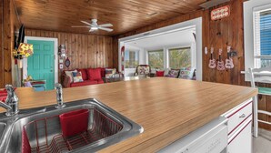 A kitchen with wooden cabinets, a stainless steel sink, and a wooden countertop.
