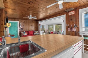A kitchen with wooden cabinets, a stainless steel sink, and a wooden countertop.