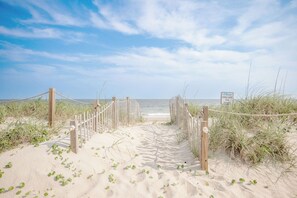 A sandy beach path leading to the ocean with a sign reading 'The Dunes.' - Island Retreat: Beautiful Oceanfront Home w/Gazebo in West Beach (Oak Island)