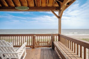 A wooden deck with a 'Welcome to the Beach' sign, wooden railings, and white Adirondack chairs. - Island Retreat: Beautiful Oceanfront Home w/Gazebo in West Beach (Oak Island)