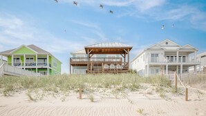 A beachfront property with a wooden structure, a green building, and a white building.