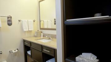 A bathroom with a sink, mirror, towel rack, toilet, and a tissue box.