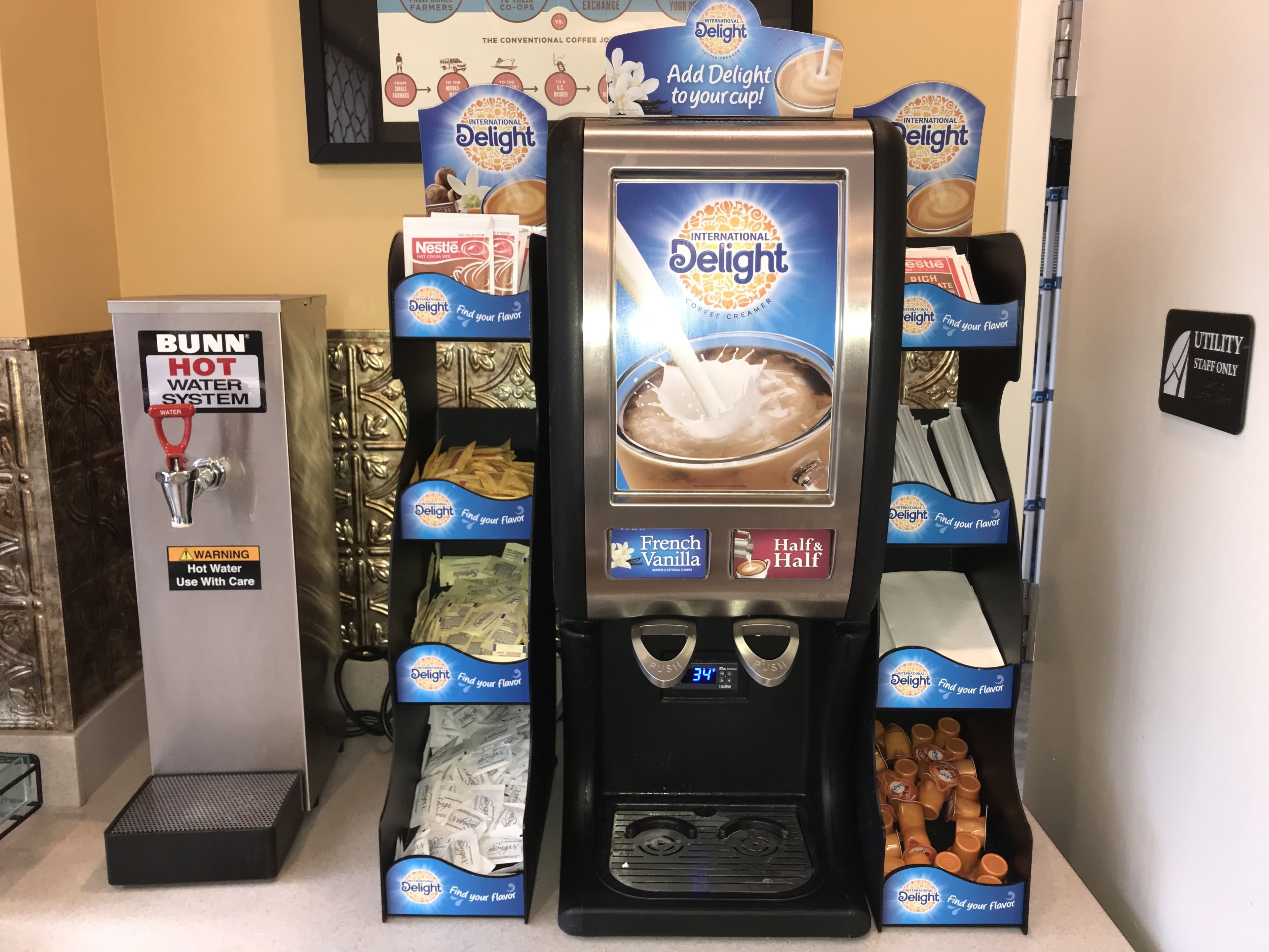 A coffee station with a Bunn hot water system and a coffee creamer dispenser.