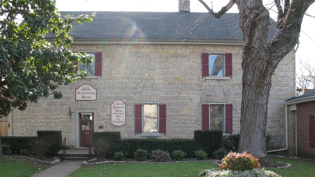 A stone building with a sign for 'Old Laundry Jail' and 'Jailer’s Inn Bed & Breakfast'.
