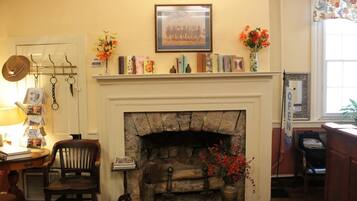 A cozy room with a fireplace, bookshelves, and a framed picture on the wall.