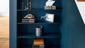 A dark blue bookshelf with decorative items and books.