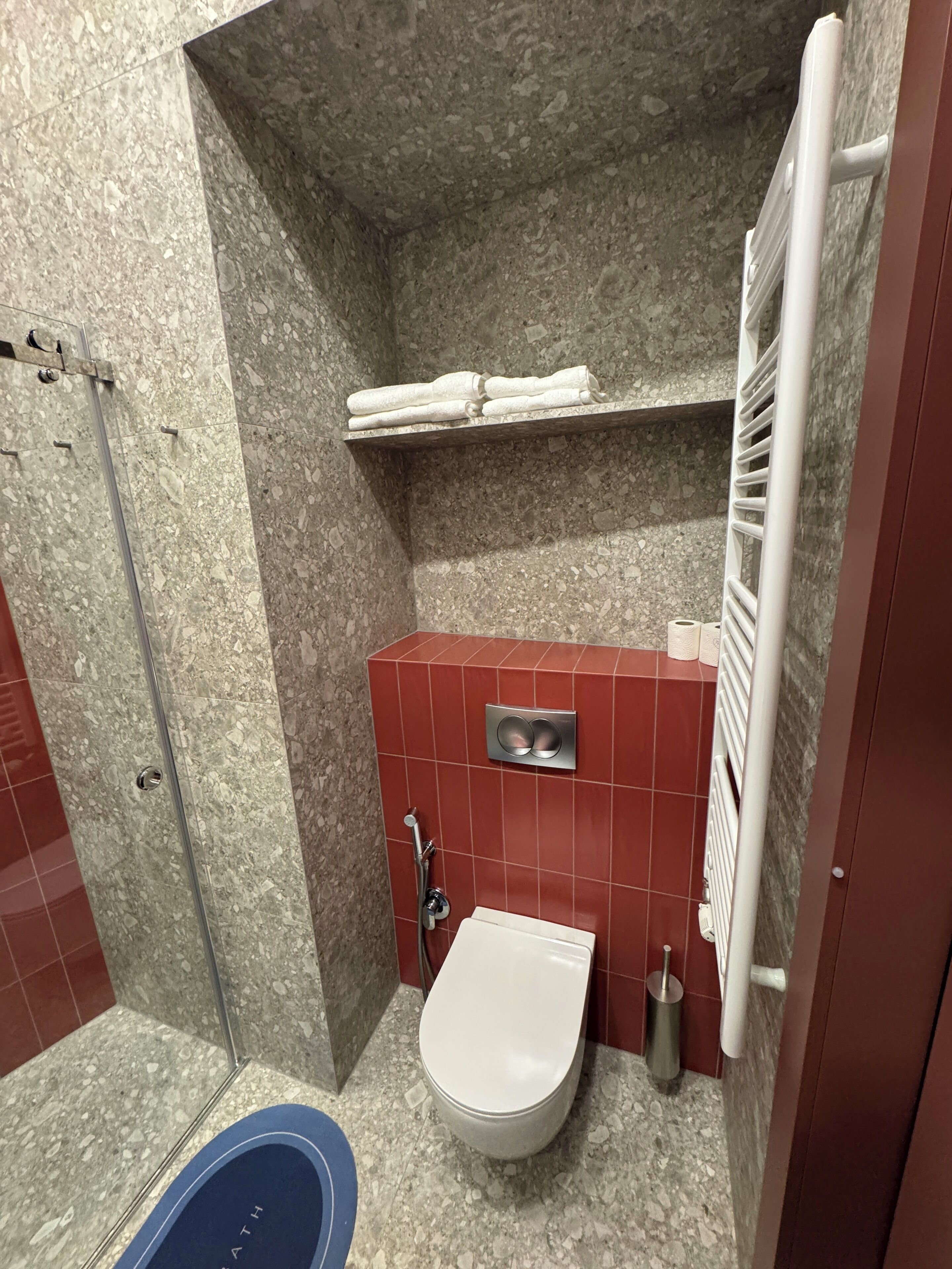 Kylpyhuone, jossa on suihku, wc ja sininen kylpyamme.