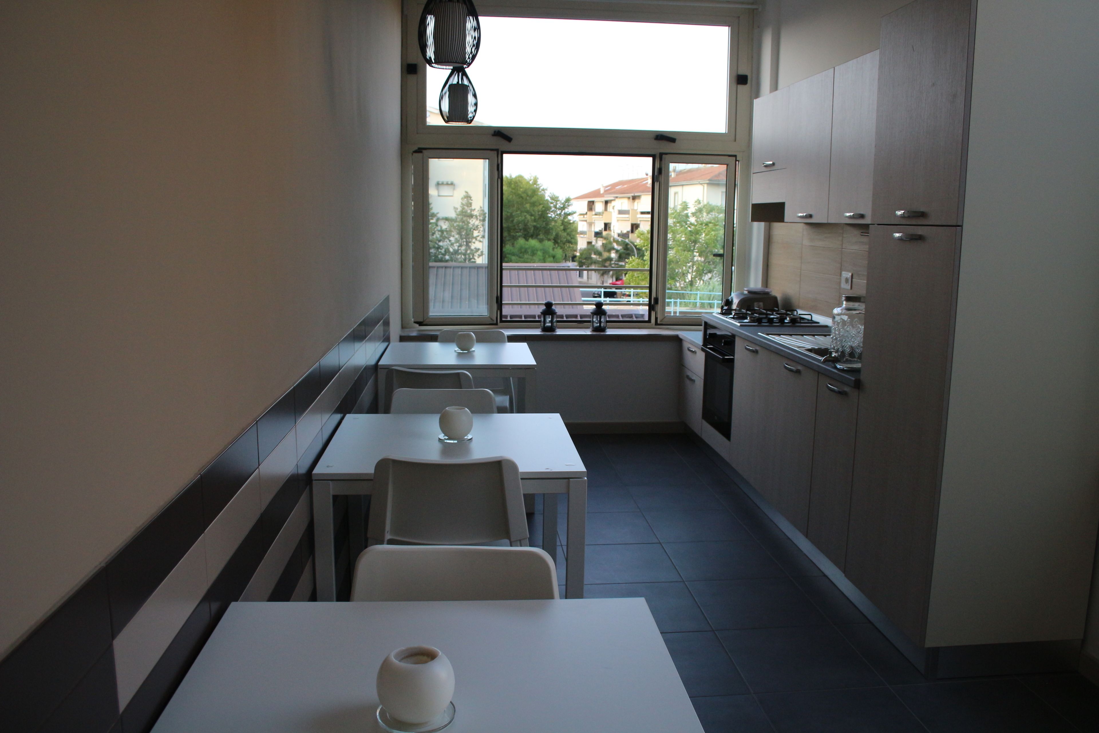 Eine moderne Küche mit Essbereich, großen Fenstern und Blick auf Gebäude.
