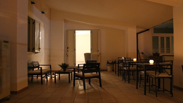 A spacious living room with a fireplace, multiple seating areas, and a view of the outside through a door.