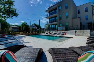 Una piscina al aire libre, sillones reclinables de piscina