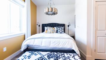 Une chambre à coucher avec un lit, un lustre et un tapis à motifs.