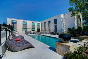 Una piscina al aire libre, sillones reclinables de piscina