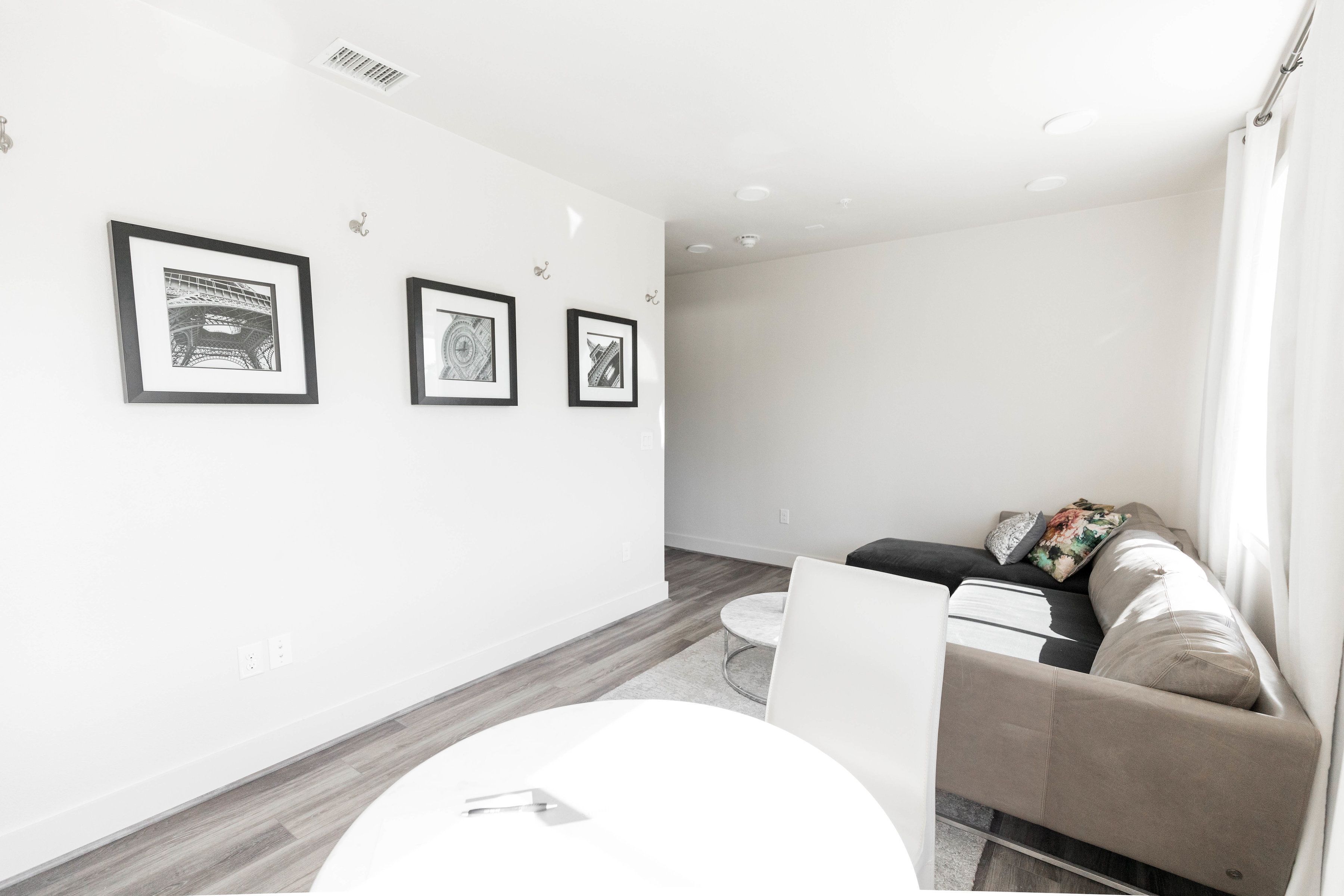 A modern living room with a sofa, a coffee table, and framed artwork on the wall.