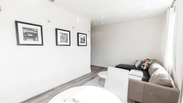 A modern living room with a sofa, a coffee table, and framed artwork on the wall.