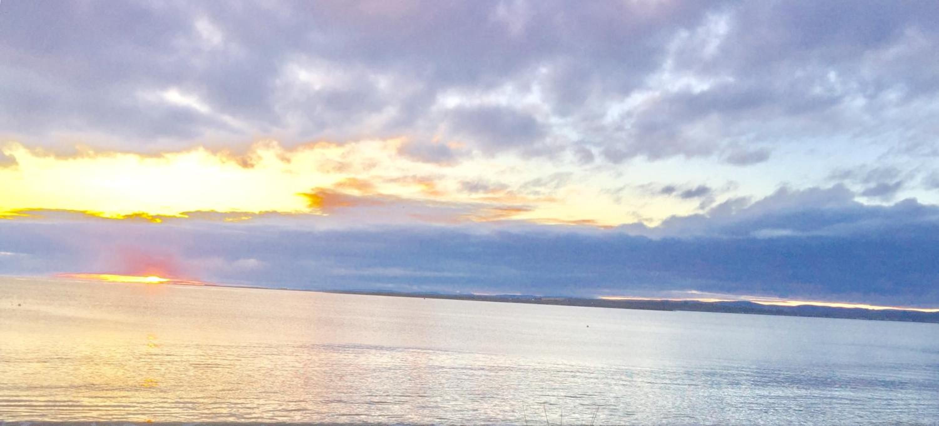Un cuerpo de agua reflejando el cielo durante el atardecer.
