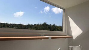 A room with a large window, a wooden shelf, and a white chair. - AgaPe Plus Home (Hengchun)