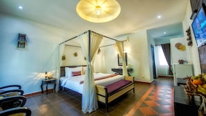 A four-poster bed with a canopy, a television mounted on the wall, and a fruit basket on the side table. - My Unique Angkor Siemreap (Siem Reap)